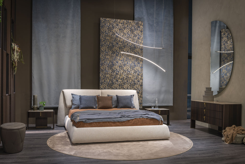 Simon Bed - Definito dal suo profilo basso, a filo pavimento, e dalla scultorea testiera imbottita, Simon unisce curve morbide a geometrie precise per creare