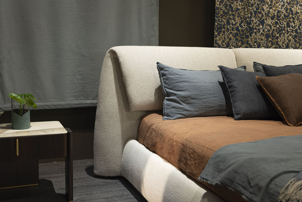 Simon Bed - Definito dal suo profilo basso, a filo pavimento, e dalla scultorea testiera imbottita, Simon unisce curve morbide a geometrie precise per creare